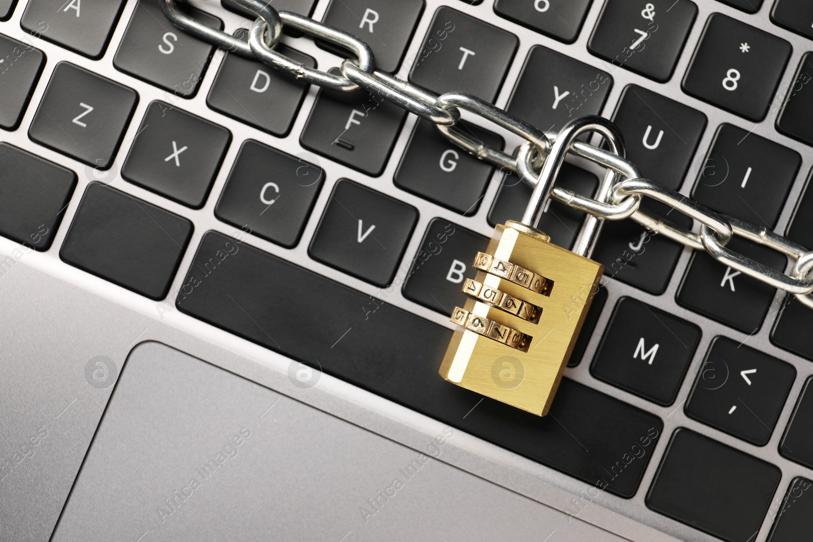 Photo of Cyber security. Padlock with chain on laptop, top view