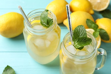 Natural lemonade with mint on light blue wooden table, closeup. Summer refreshing drink