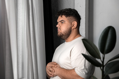 Photo of Overweight man suffering from depression at home