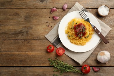 Photo of Tasty spaghetti squash with tomato sauce and thyme served on wooden table, flat lay. Space for text