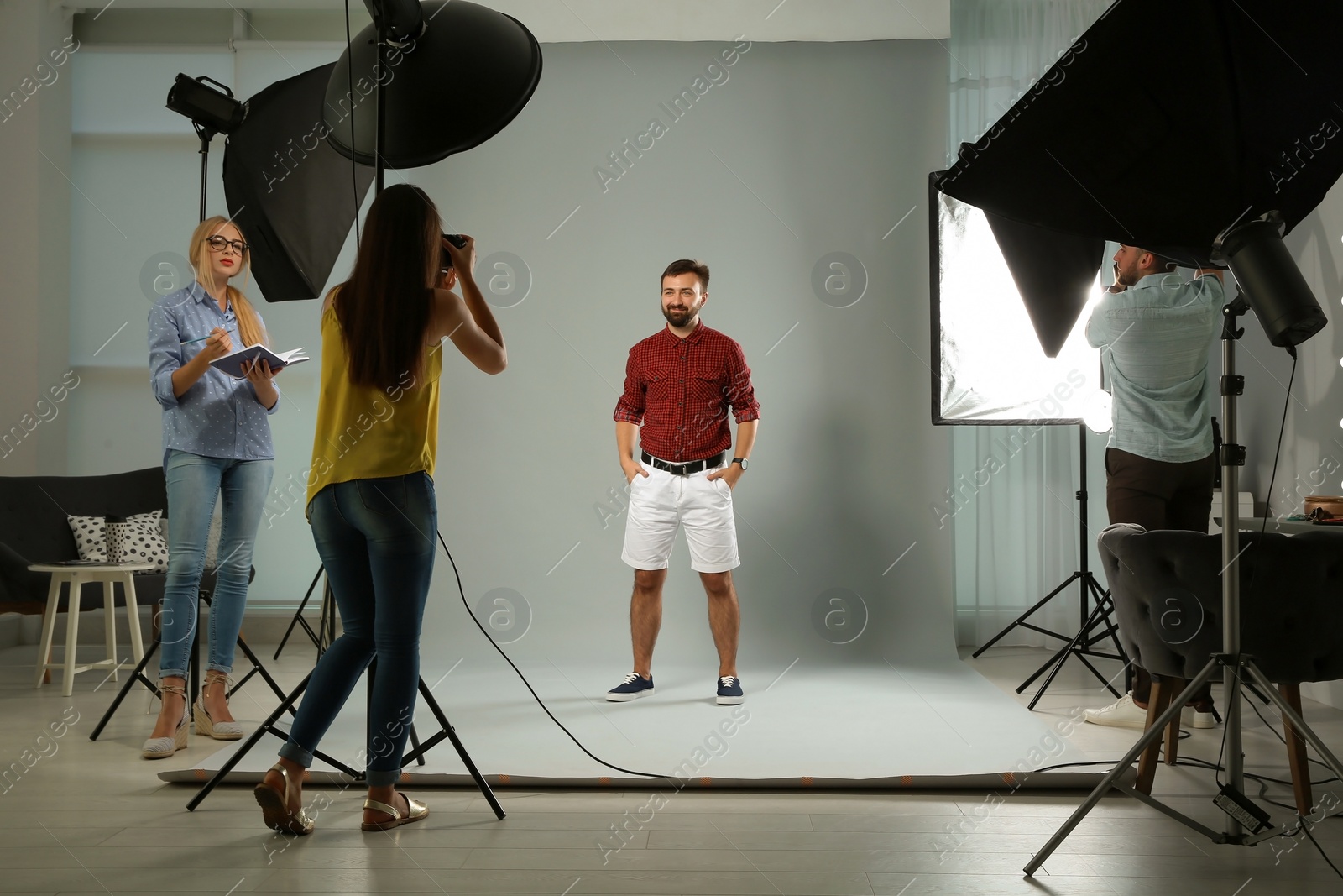 Photo of Professional team working with model in photo studio