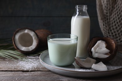 Composition with coconut milk on wooden table, space for text