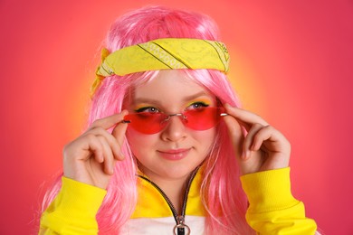 Photo of Cute indie girl with sunglasses on bright pink background