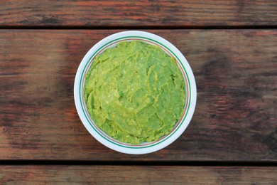 Delicious guacamole made of avocados on wooden table, top view