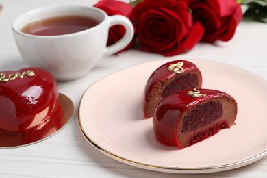Photo of St. Valentine's Day. Pieces of delicious cake served on white table, closeup