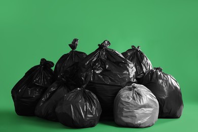 Photo of Trash bags full of garbage on green background