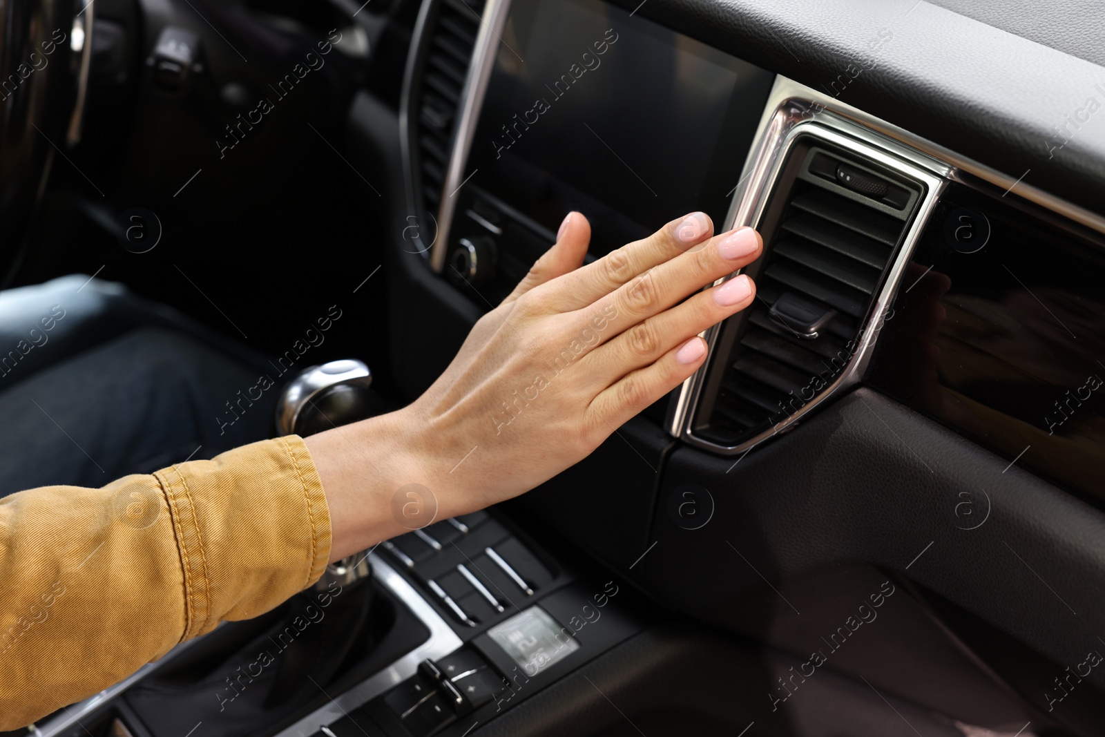 Photo of Woman checking air conditioner in her car, closeup