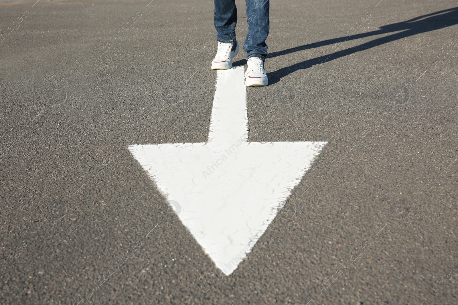 Photo of Man going along road with arrow marking, closeup