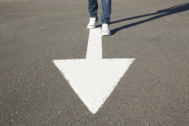 Photo of Man going along road with arrow marking, closeup