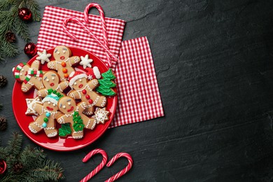 Photo of Flat lay composition with delicious Christmas cookies on black table, space for text