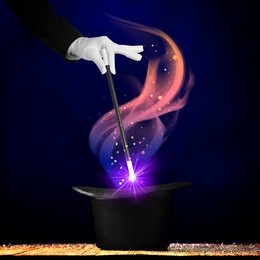 Image of Wizard conjuring magical light out of hat with wand on dark background, closeup