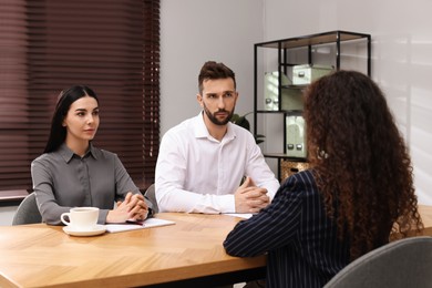 Photo of Coworkers conducting job interview with African American woman in office. Racism concept