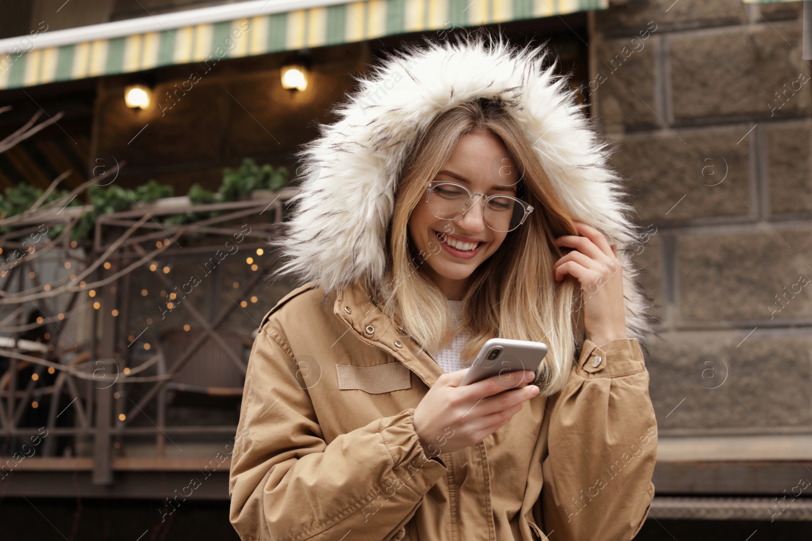 Photo of Beautiful young woman using mobile phone outdoors