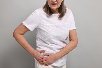 Photo of Arthritis symptoms. Woman suffering from hip joint pain on gray background, closeup