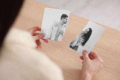 Image of Divorce and breakup. Woman holding parts of ripped black and white photo at table, closeup