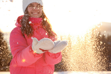 Young woman having fun outdoors on snowy winter day. Space for text