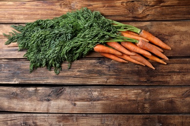 Fresh carrots on wooden table, top view. Space for text