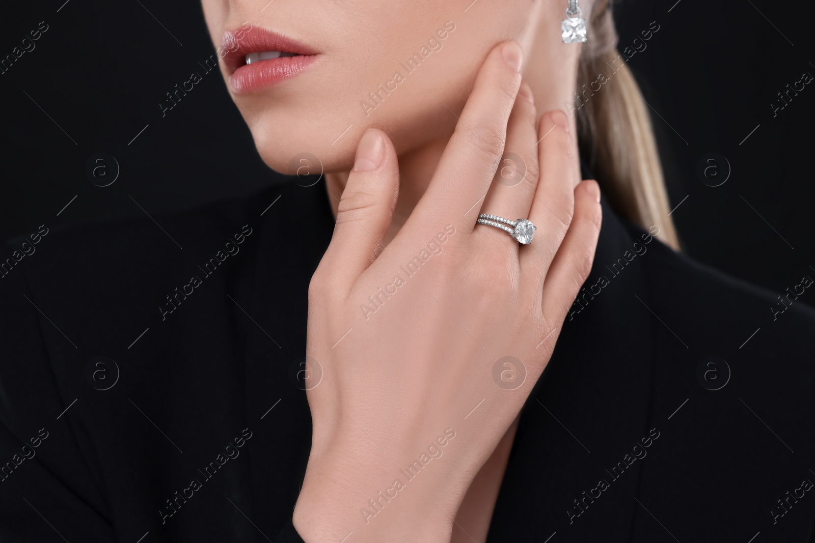 Photo of Woman with elegant jewelry on black background, closeup