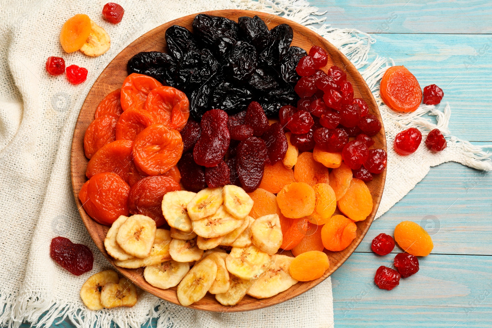 Photo of Delicious dried fruits on light blue wooden table, flat lay