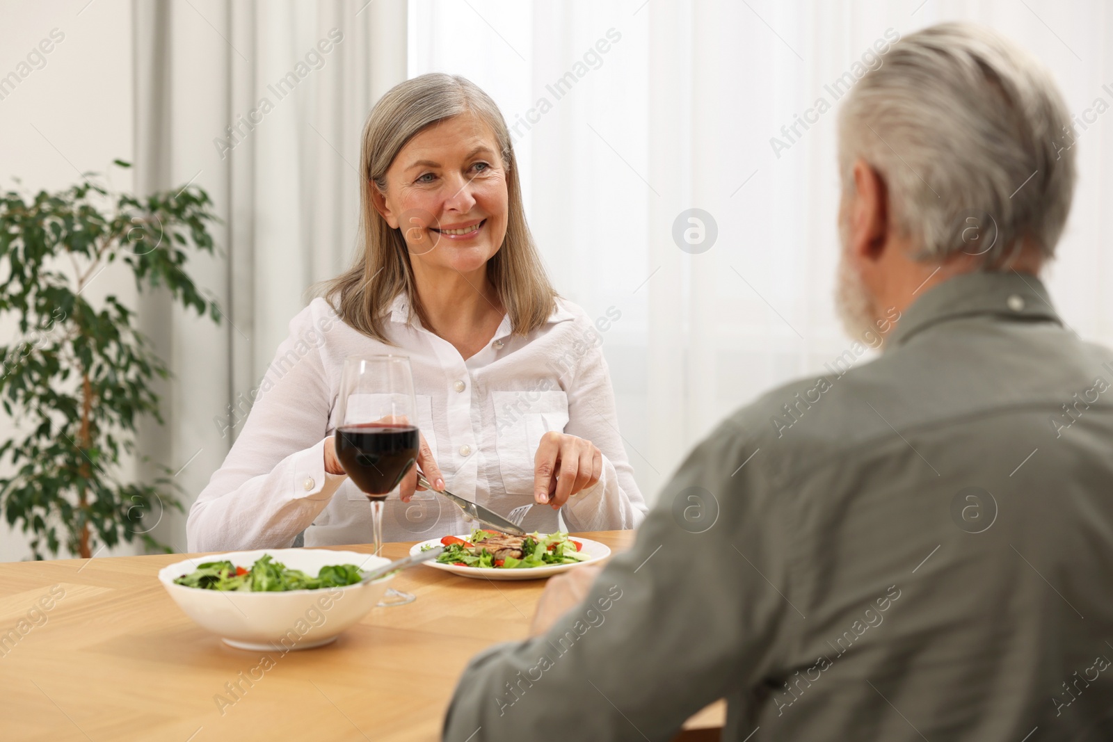 Photo of Happy senior couple having romantic dinner at home