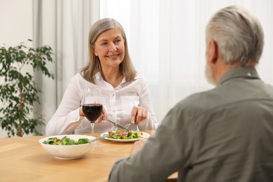 Happy senior couple having romantic dinner at home