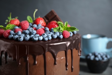 Photo of Freshly made tasty chocolate cake decorated with berries on table, closeup