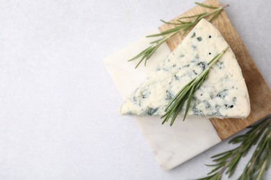 Photo of Tasty blue cheese with rosemary on light table, flat lay. Space for text
