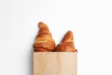Photo of Paper bag with croissants on white background, top view. Space for design