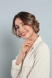 Photo of Young woman with beautiful hairstyle on light grey background