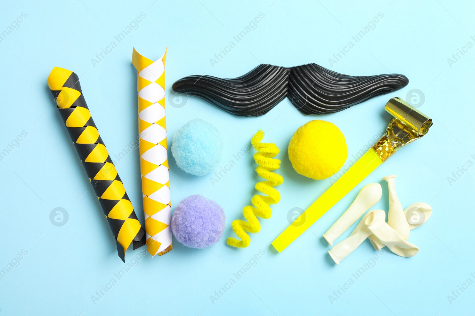 Photo of Different clown's accessories on light blue background, flat lay