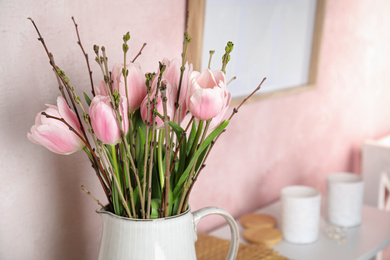 Photo of Beautiful bouquet with spring pink tulips on table. Space for text