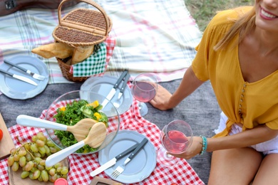 Photo of Young woman having picnic outdoors on summer day, closeup