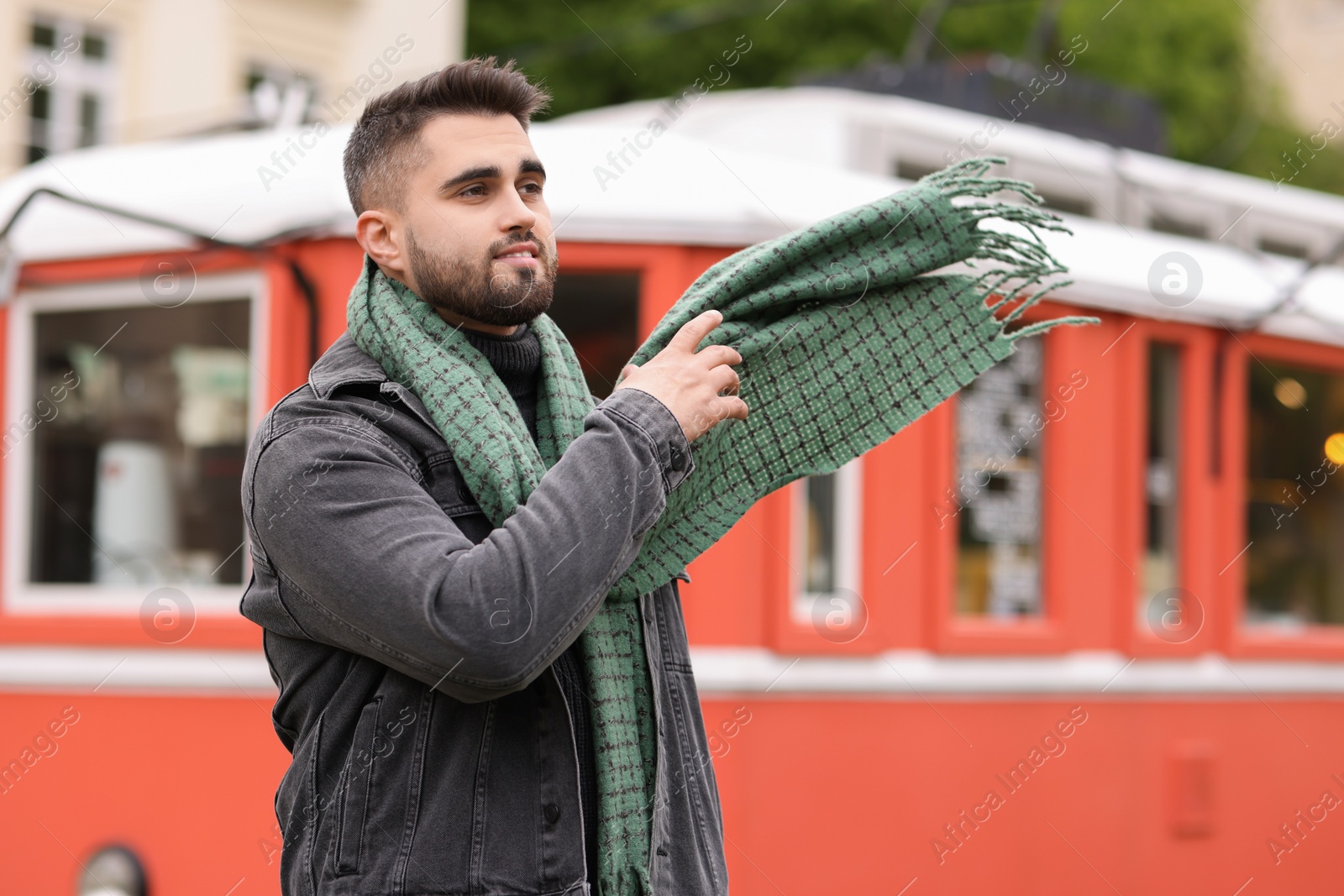 Photo of Smiling man in warm scarf outdoors. Space for text