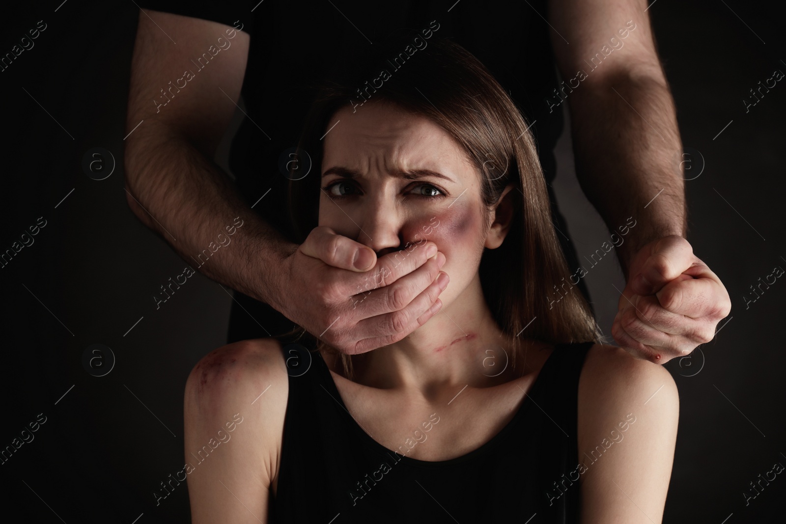 Photo of Man abusing scared woman on black background. Domestic violence