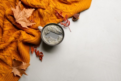 Flat lay composition with hot drink and warm plaid on light table, space for text