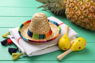 Mexican sombrero hat, maracas and poncho on turquoise wooden table