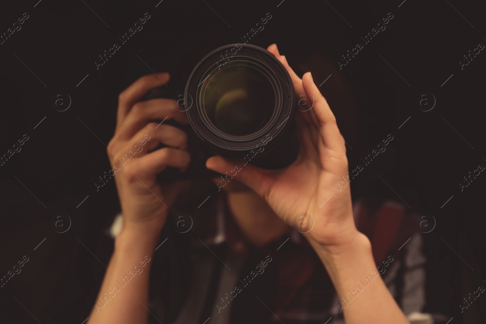 Photo of Private detective with camera spying against black background, focus on lens