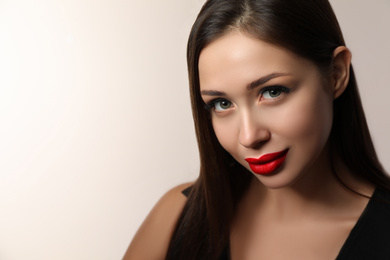 Photo of Beautiful woman with red lipstick on light background, space for text