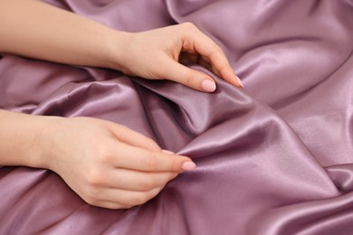 Photo of Woman touching smooth silky fabric, closeup view