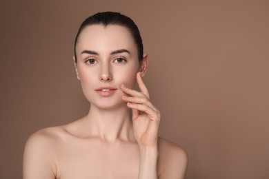 Portrait of beautiful young woman on brown background. Space for text