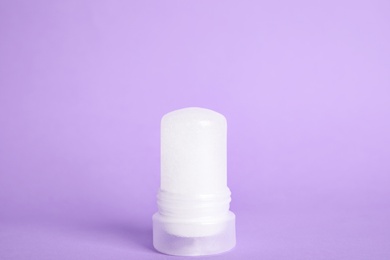 Photo of Natural crystal alum stick deodorant on lilac background