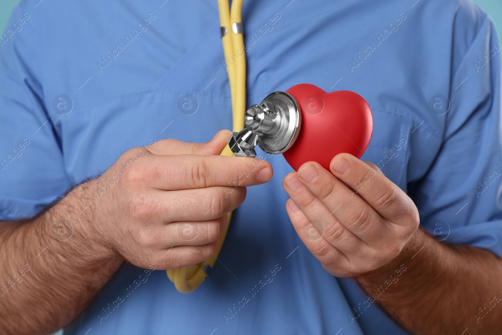 Photo of Doctor with stethoscope and red heart, closeup. Cardiology concept