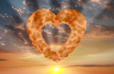 Image of Picturesque sunset with heart formed from clouds in sky