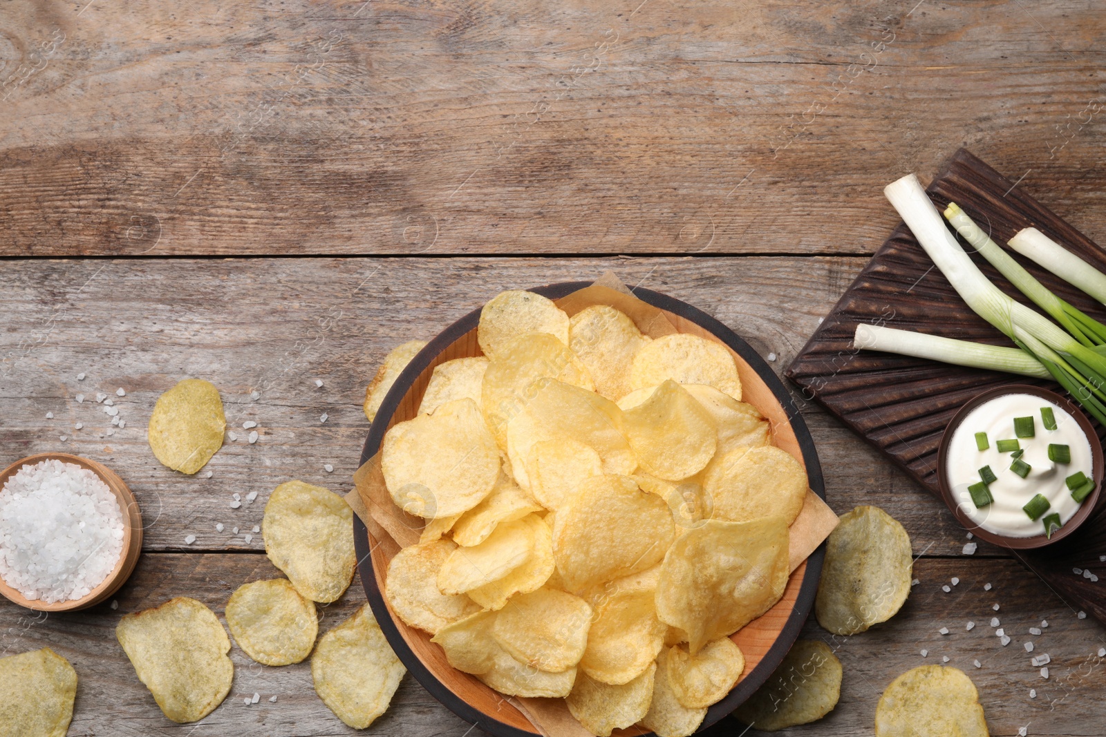 Photo of Flat lay composition with delicious crispy potato chips on table, space for text