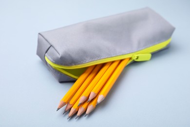 Photo of Many sharp pencils in pencil case on light grey background