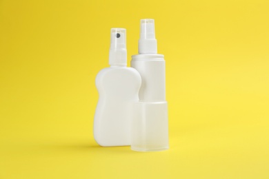 Bottles of insect repellent on yellow background