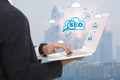 Image of SEO directions with icons of keyword research, customization and others. Man using laptop