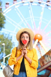 Beautiful woman with candy having fun at amusement park