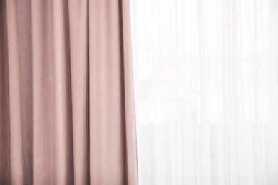 Photo of Window with elegant curtains indoors, closeup view