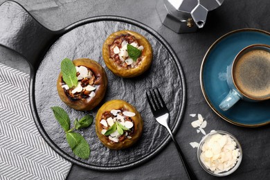 Photo of Delicious baked apples with nuts and mint served on black table, flat lay